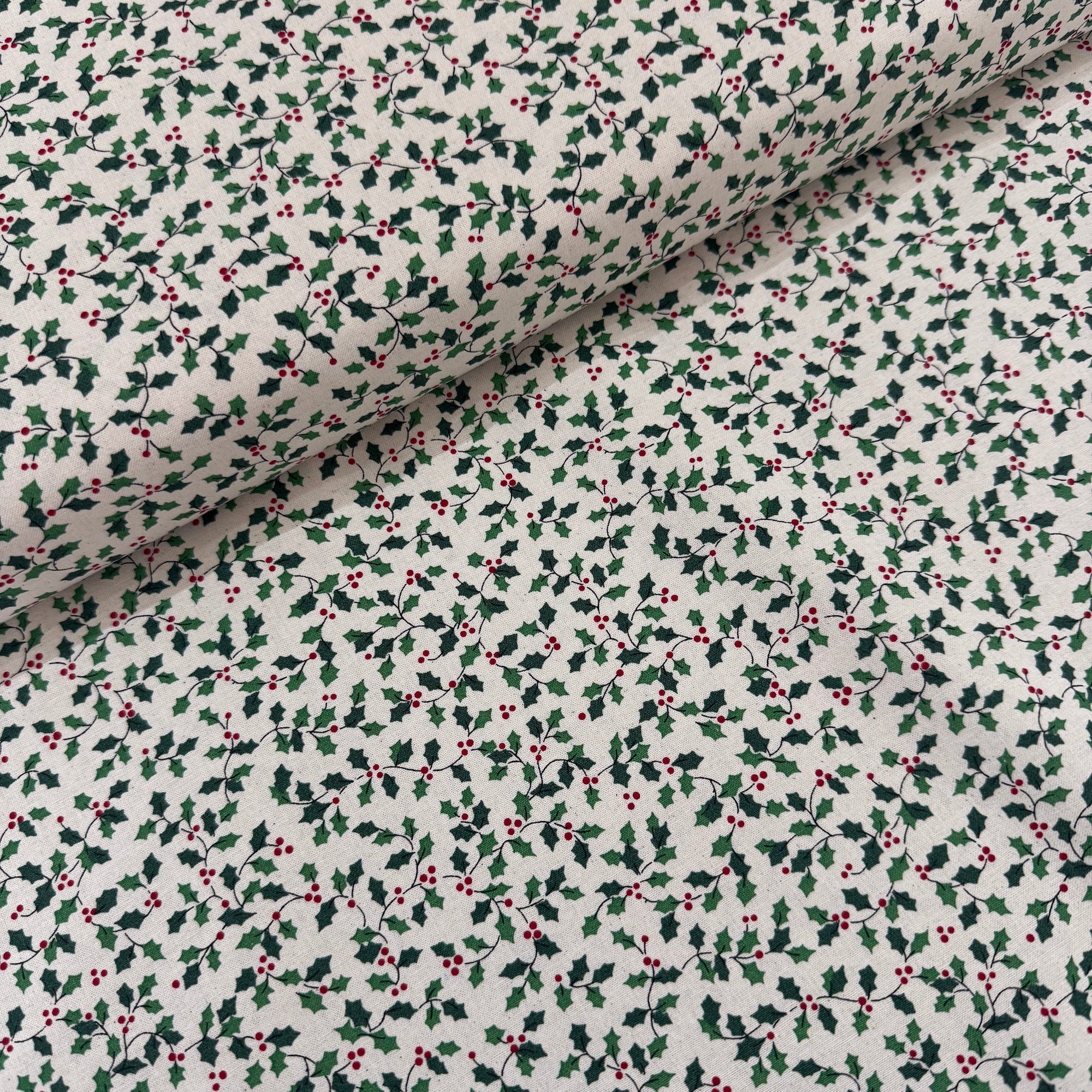 Fabric with holly berry pattern on a white background