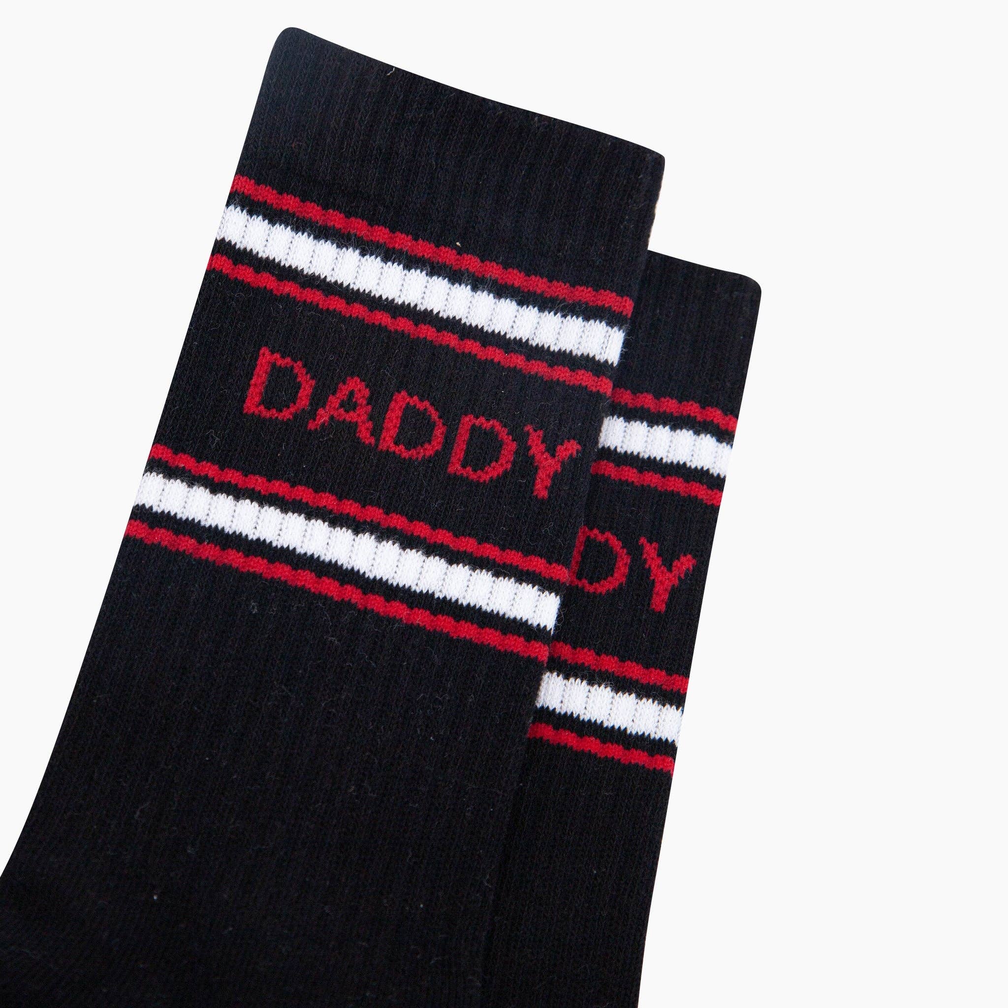 Black sock with red and white stripes and 'DADDY' text on a white background