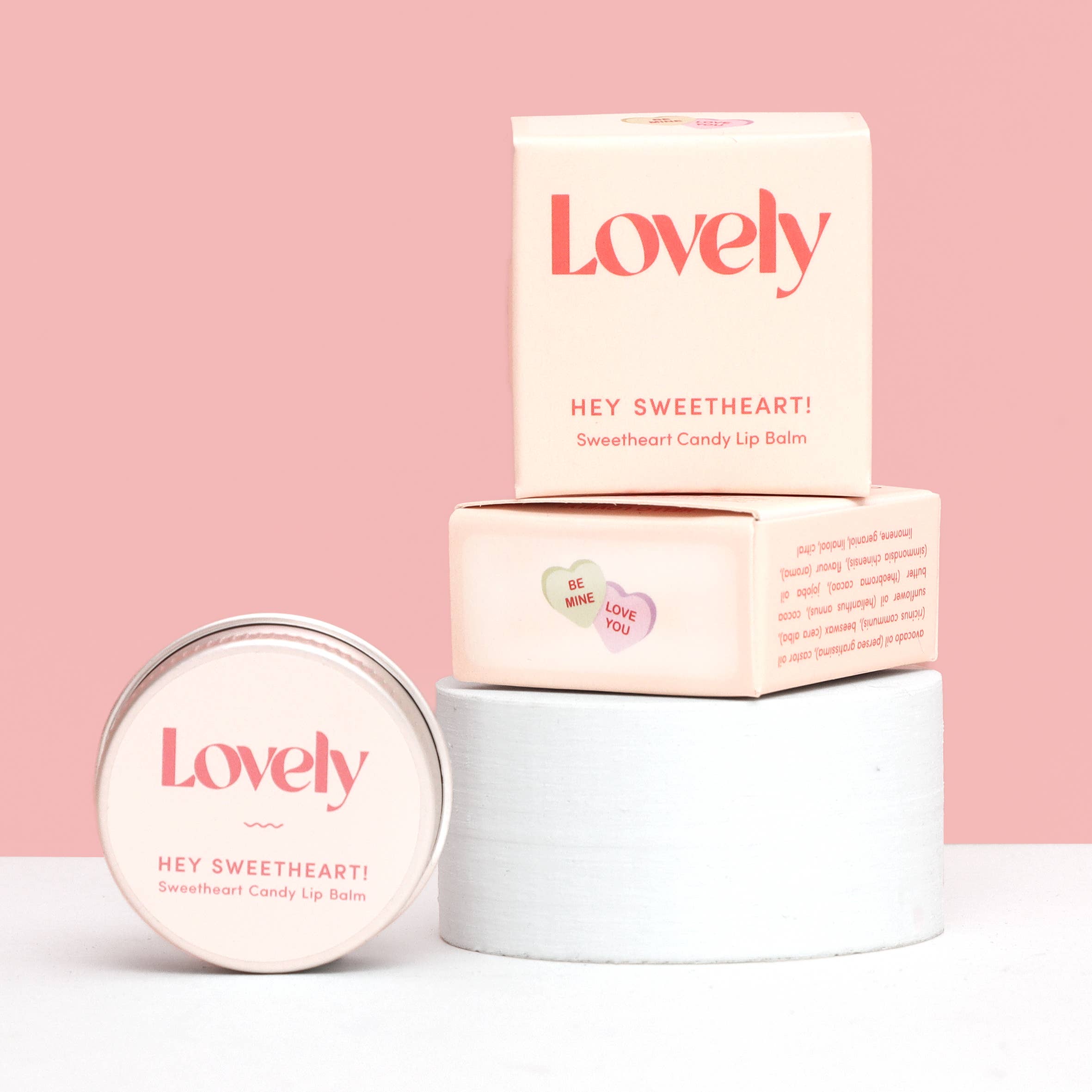 Lip balm packaging with 'Lovely' branding on a pink background
