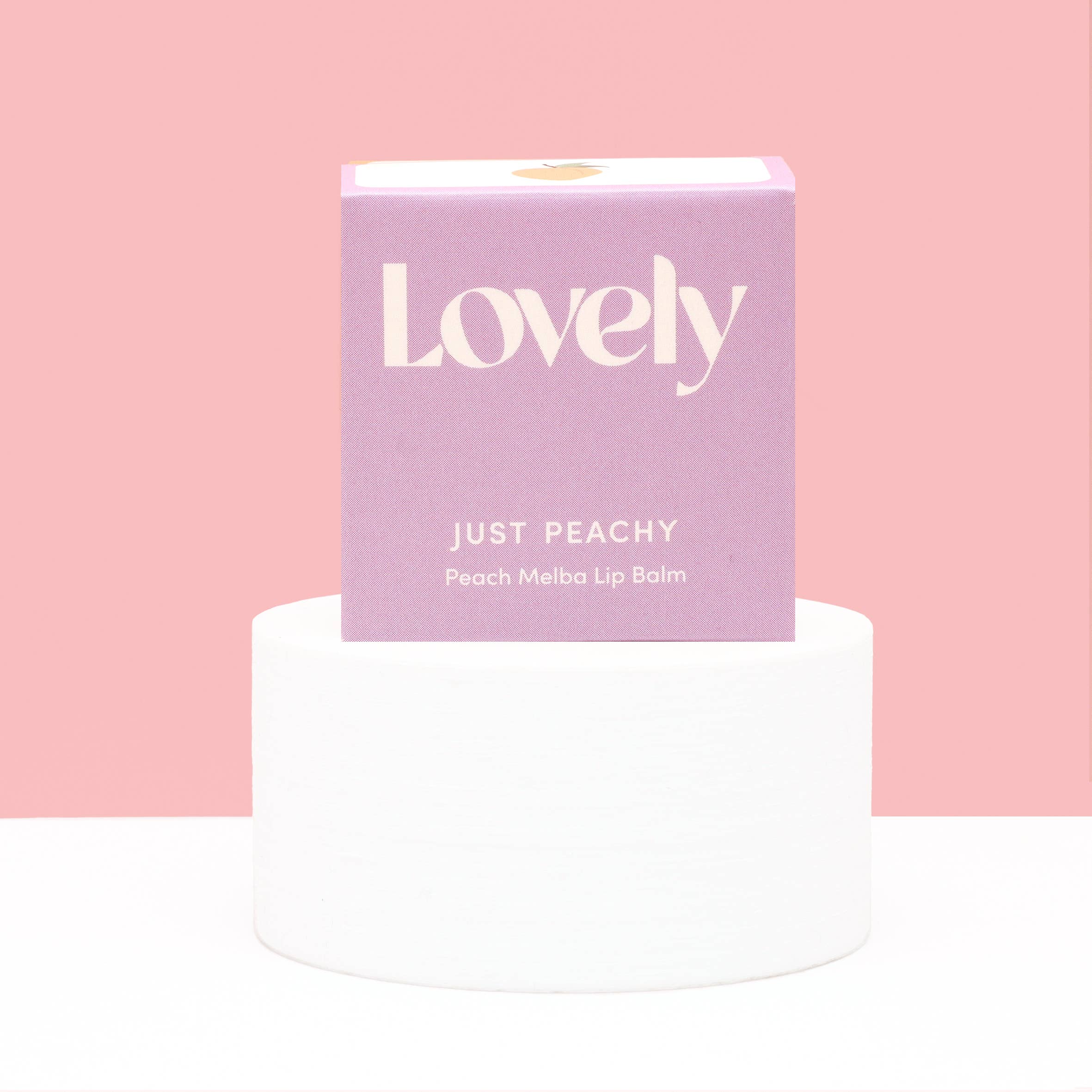 Lip balm packaging with 'Lovely' branding on a pink background