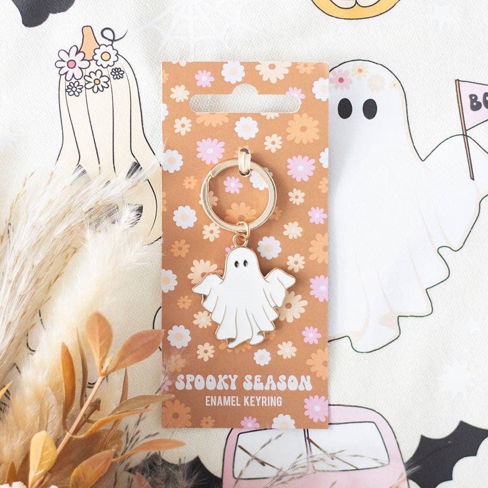 Spooky season enamel keyring on a floral patterned card with Halloween-themed decorations.