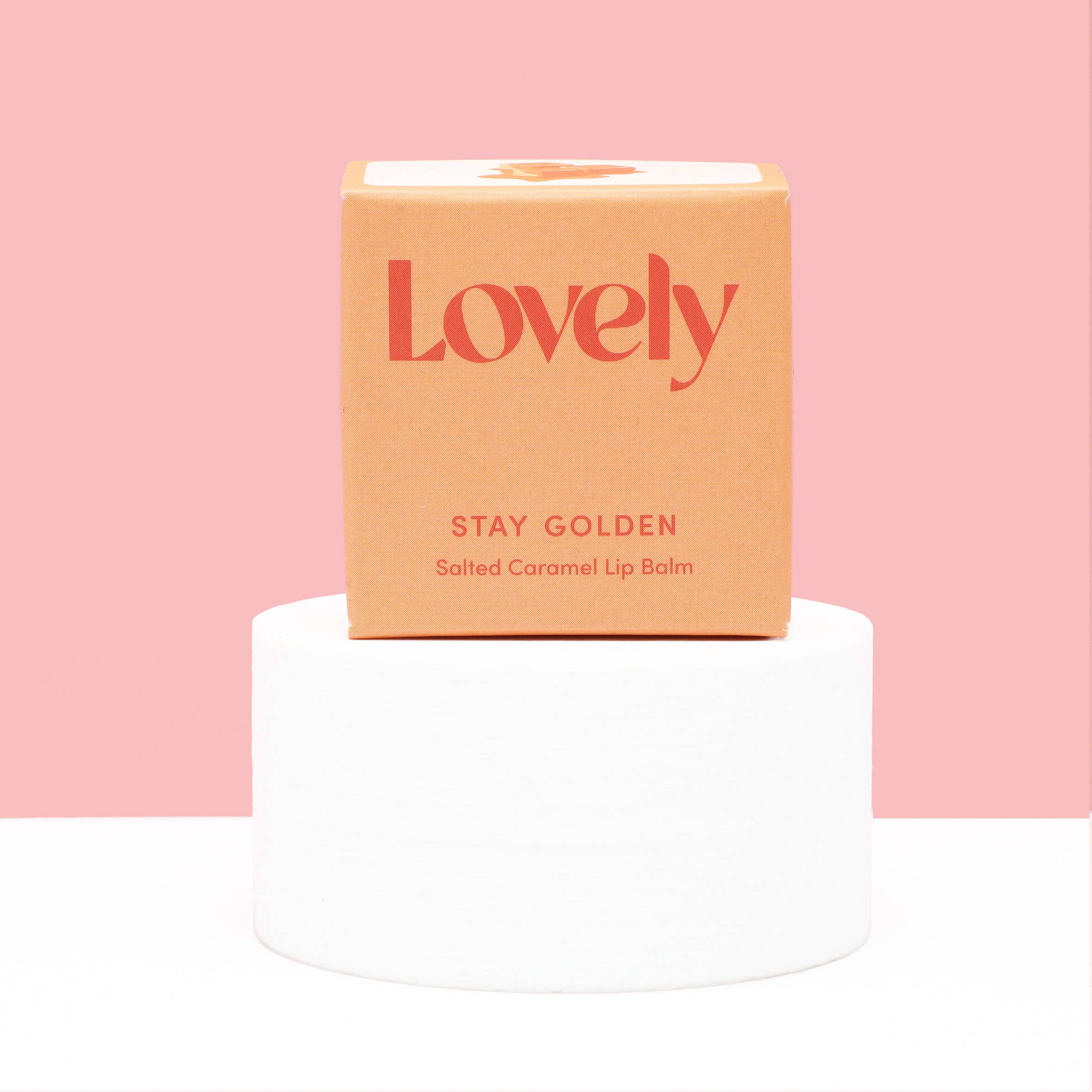 Lip balm packaging with 'Lovely' branding on a pink background