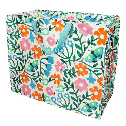 Floral and butterfly patterned storage bag with blue handles on a white background