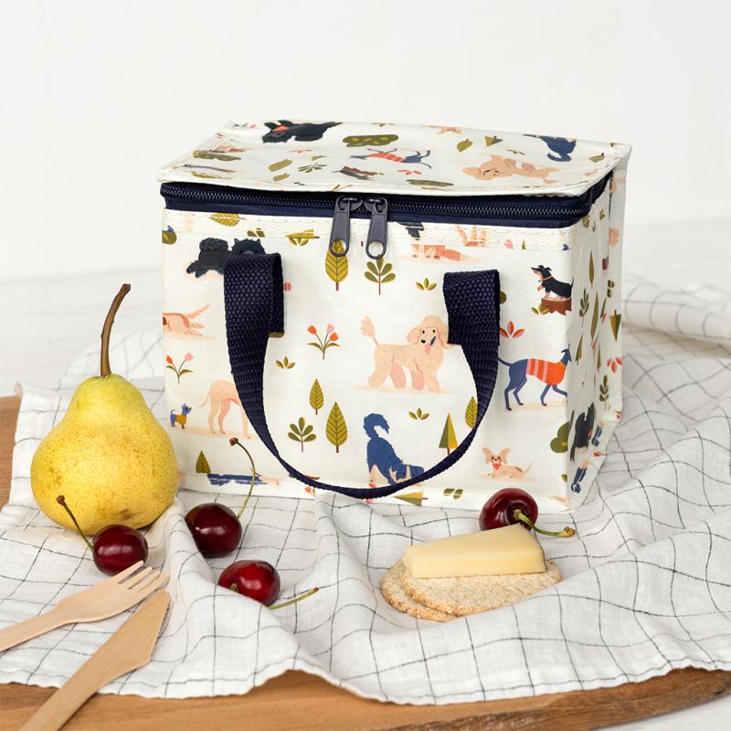 Insulated lunch bag with dog park pattern on a table with fruits and cheese