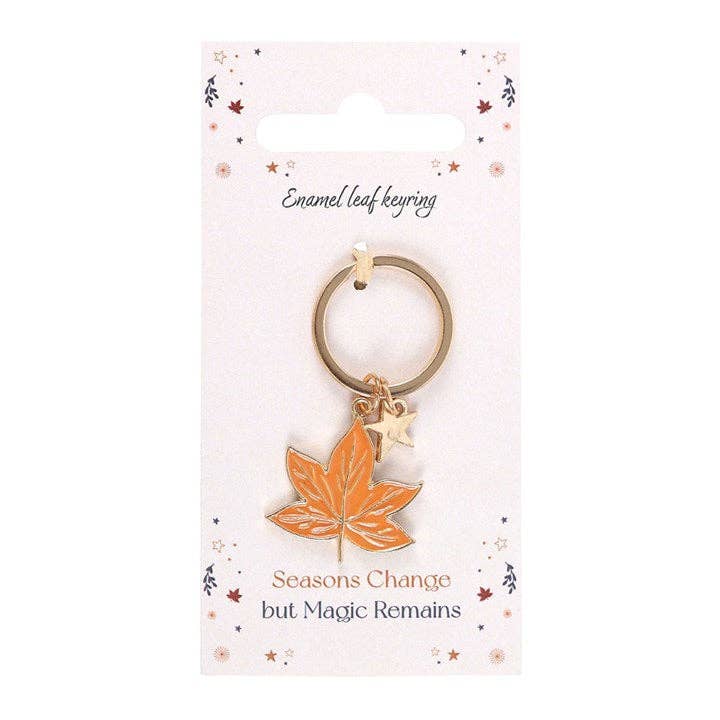 Keychain with orange leaf charm on a white card with text