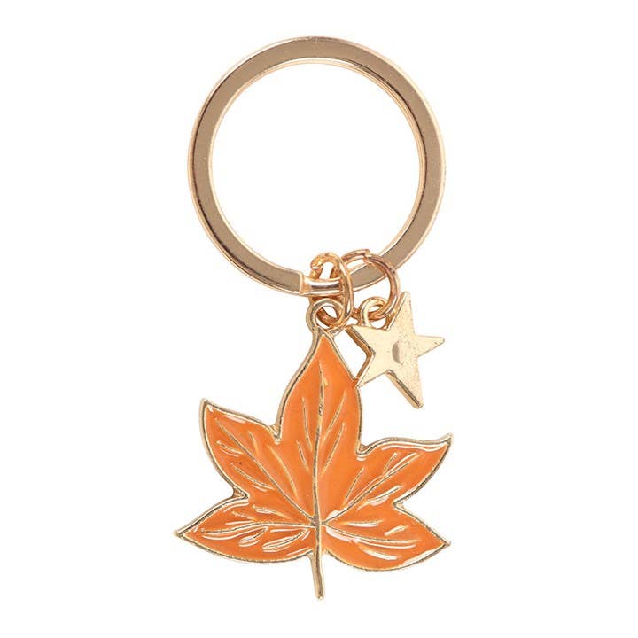 Keychain with orange leaf and gold star charm on a white background