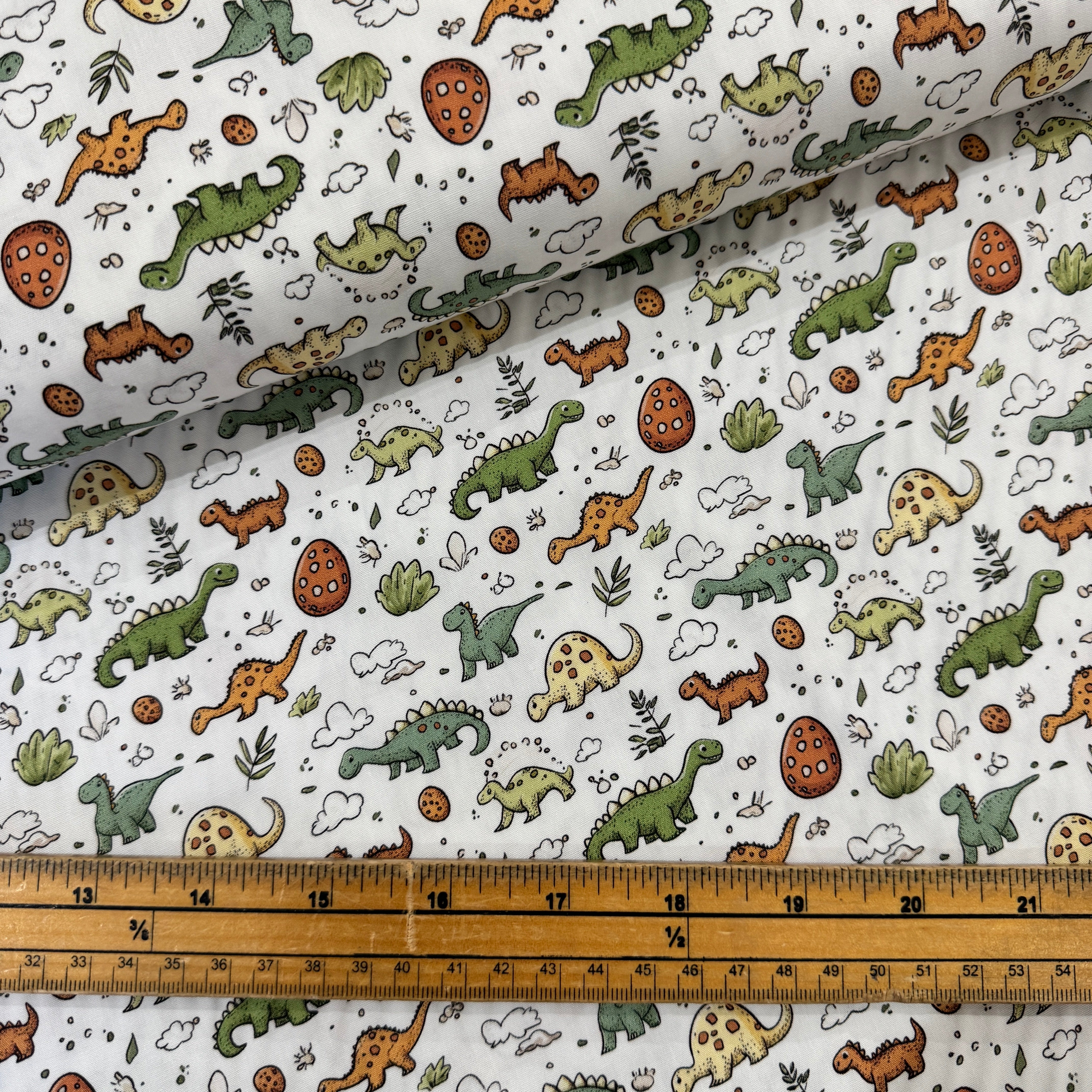 Rose & Hubble Baby Dinosaurs on Ivory Cotton Poplin Fabric ay Bibelot Leek