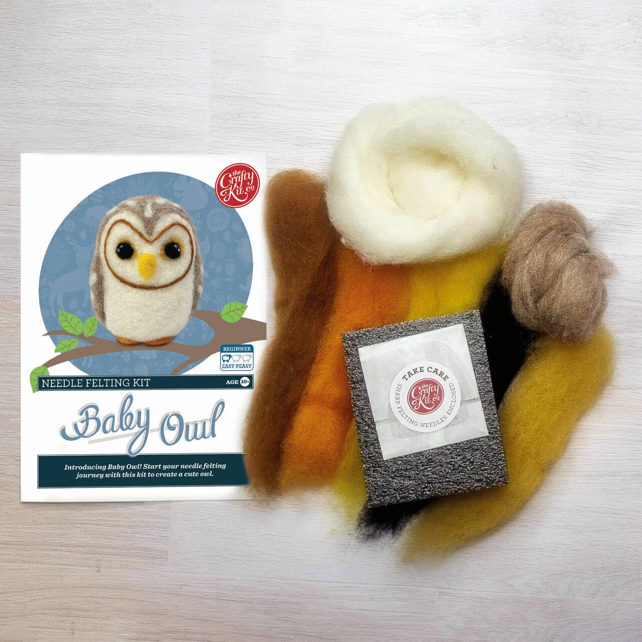 Needle felting kit with materials and packaging on a white background