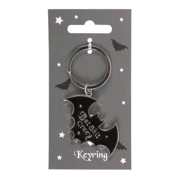Black bat-shaped keyring on a gray card with decorative elements