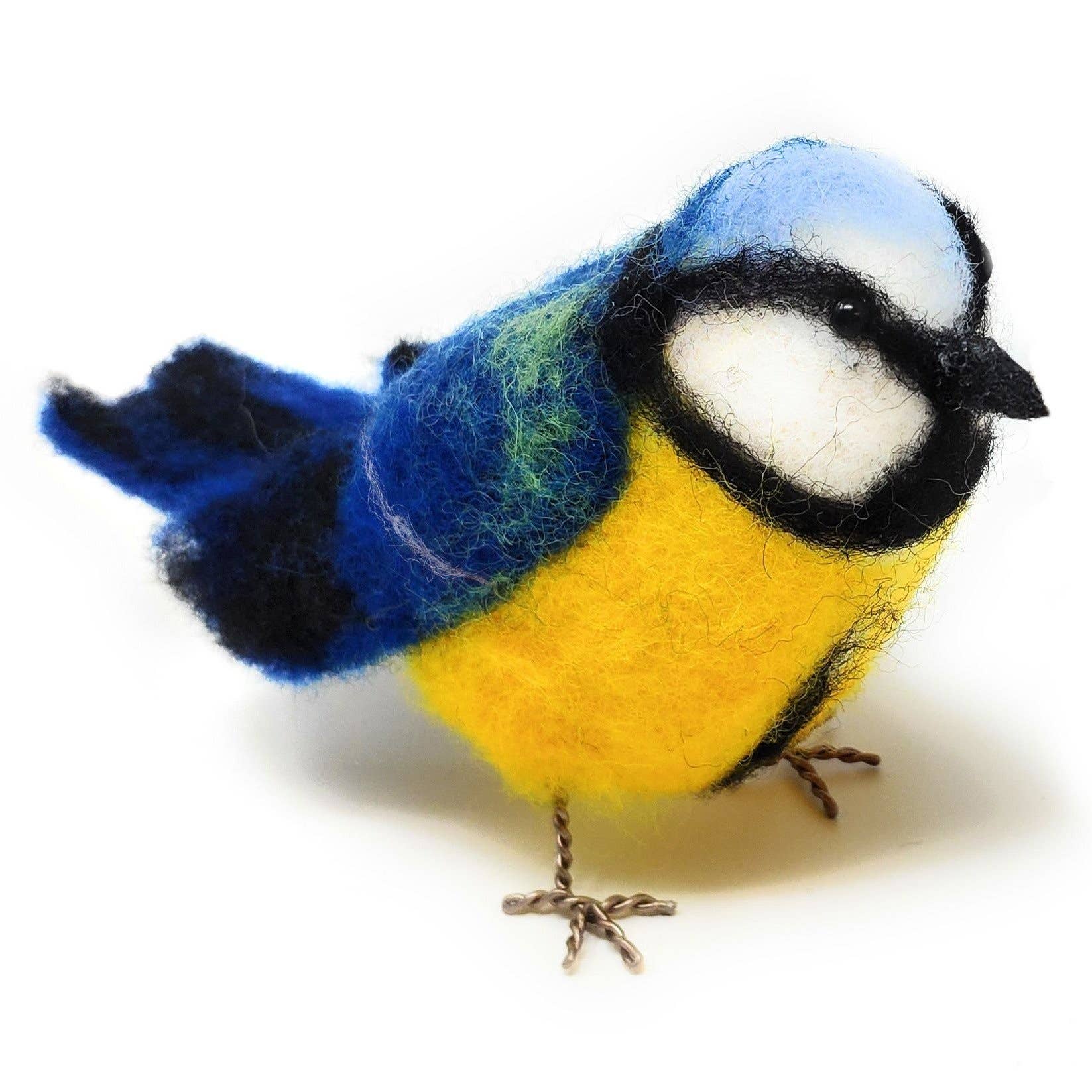 Felted bird figurine with blue, yellow, and white colors on a white background