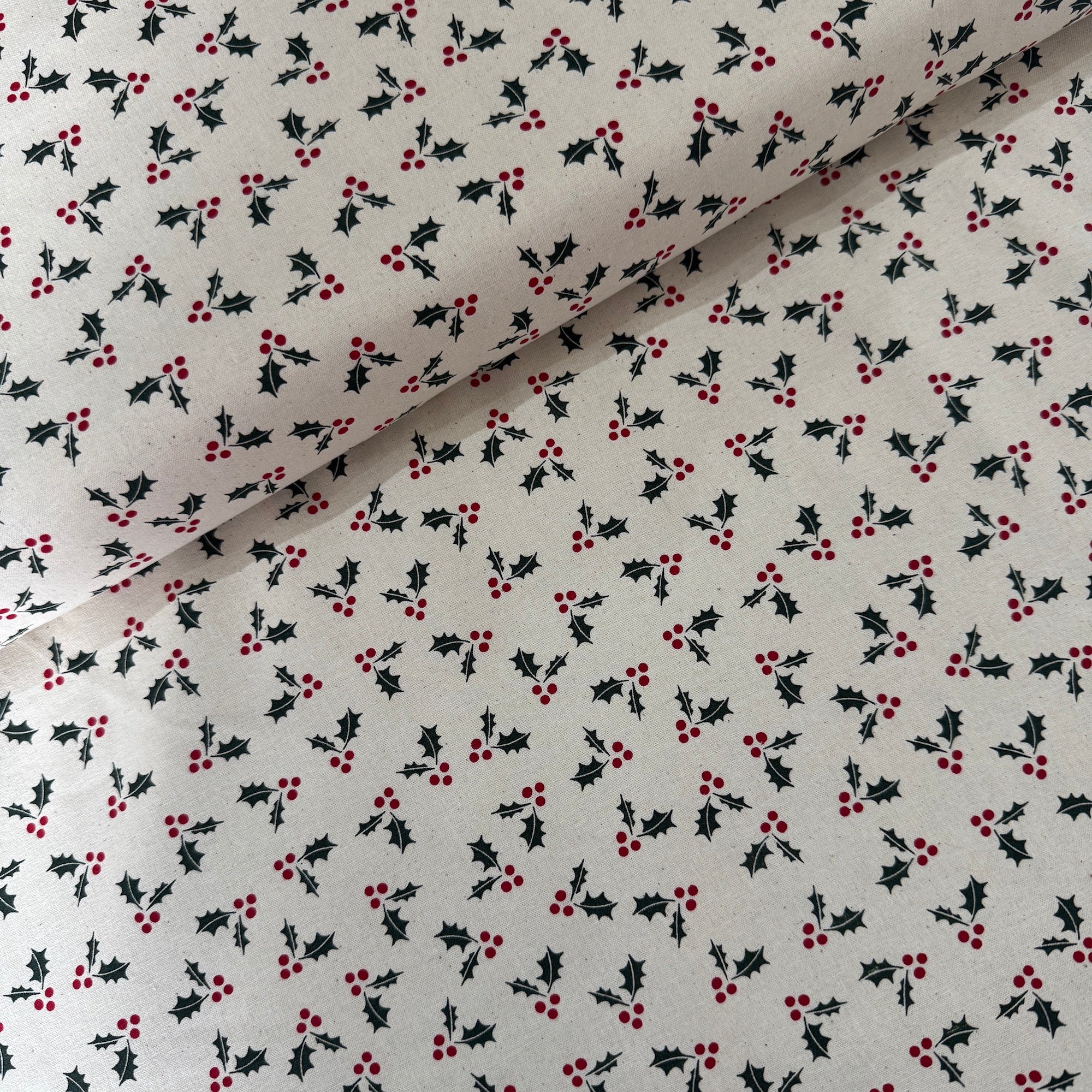 Fabric with holly berry pattern on a white background