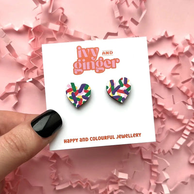Colorful earrings on a 'Ivy and Ginger' branded card with pink confetti background