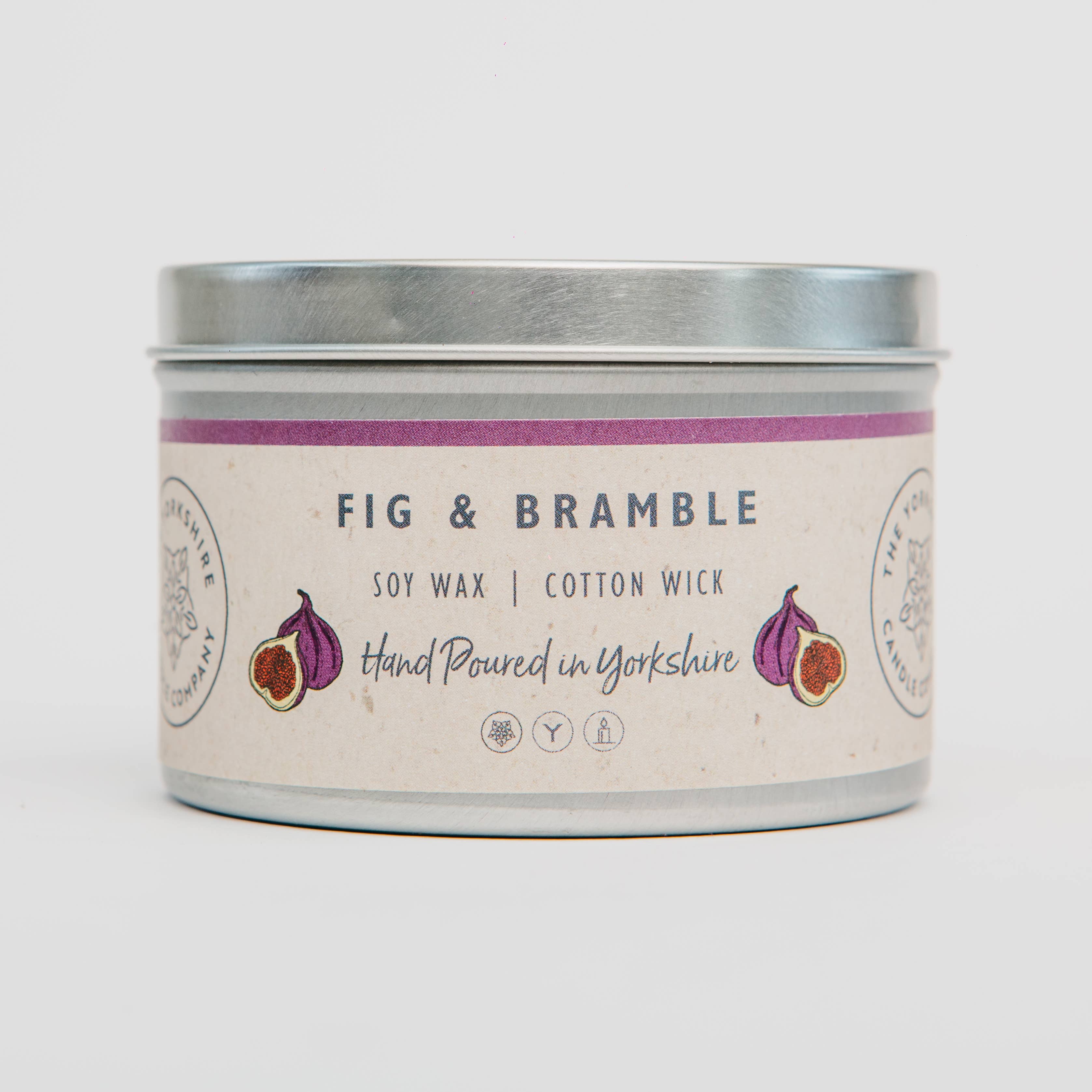 Candle tin labeled 'Fig & Bramble' with a purple band on a white background