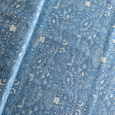 Fabric with nature-themed pattern including mushrooms, leaves, and butterflies on a blue background.