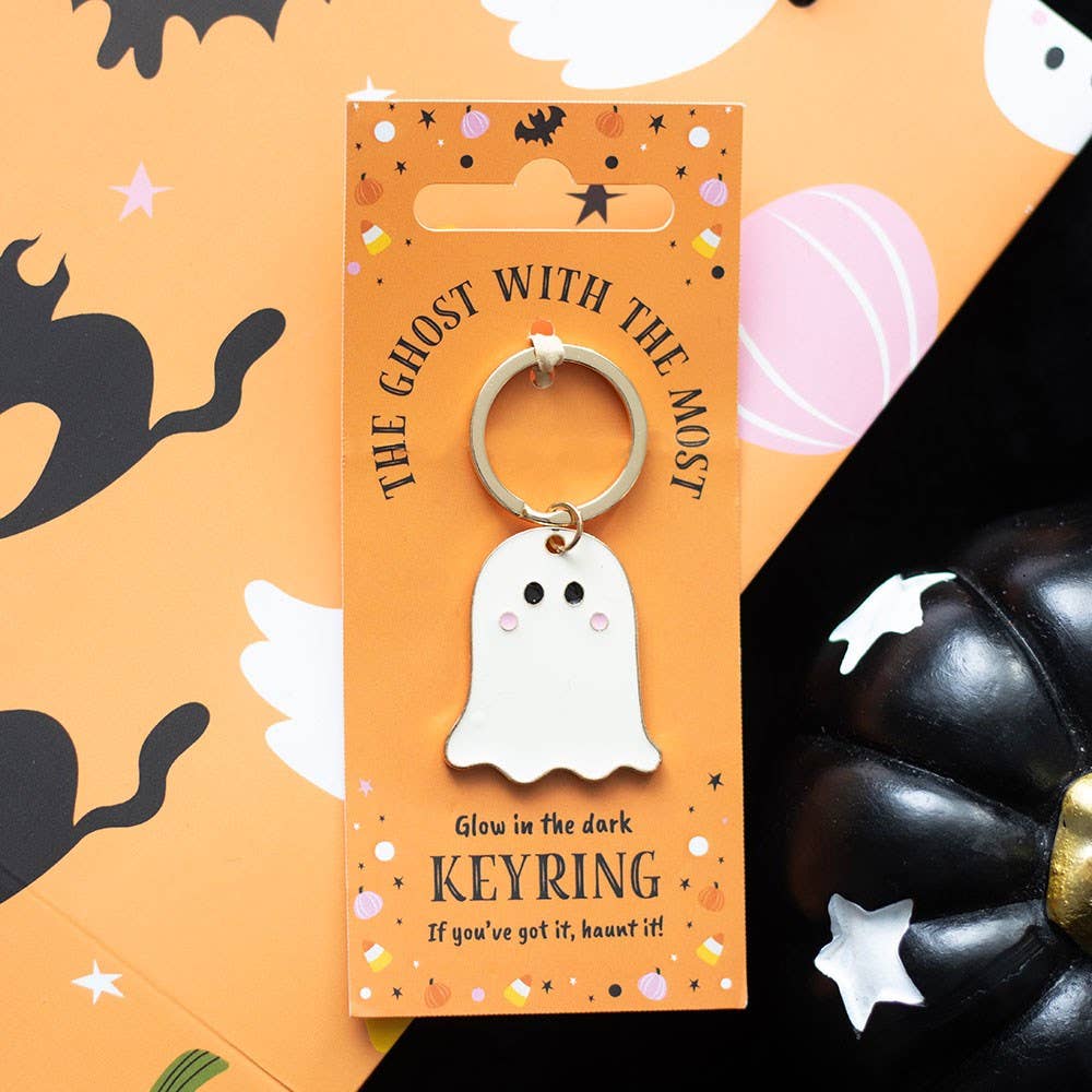 Glow-in-the-dark ghost keyring on an orange card with Halloween-themed illustrations