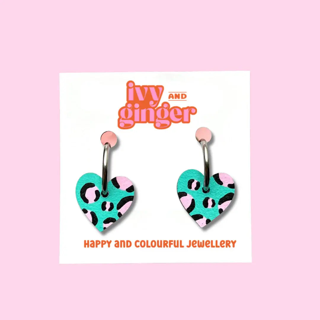 Heart-shaped earrings with a leopard print design on a 'ivy and ginger' branded card.