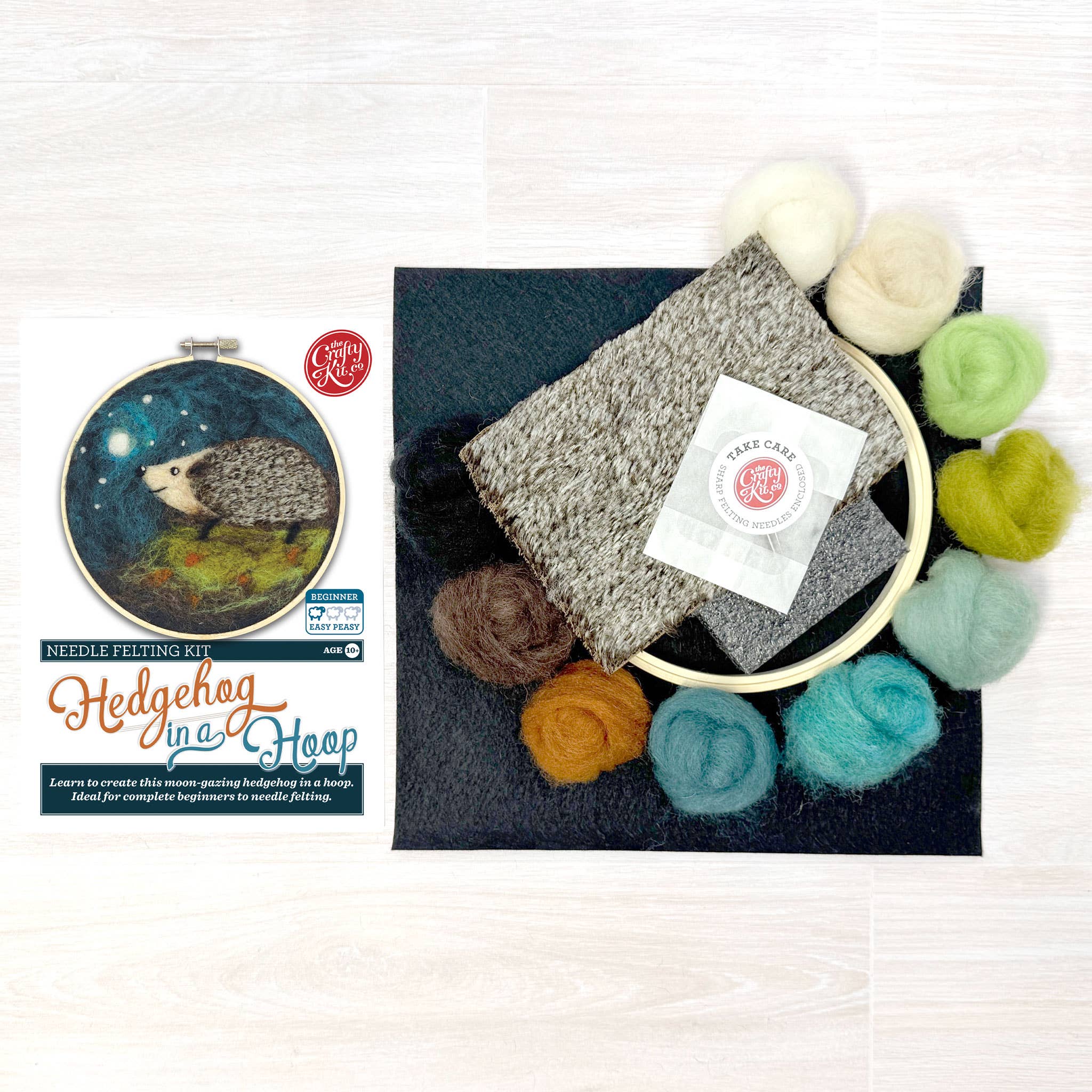 Needle felting kit with felted product, wool roving, and needle Felting Kit branding on a white background.