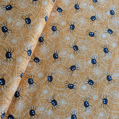 Fabric with black spiders and web pattern on a brown background