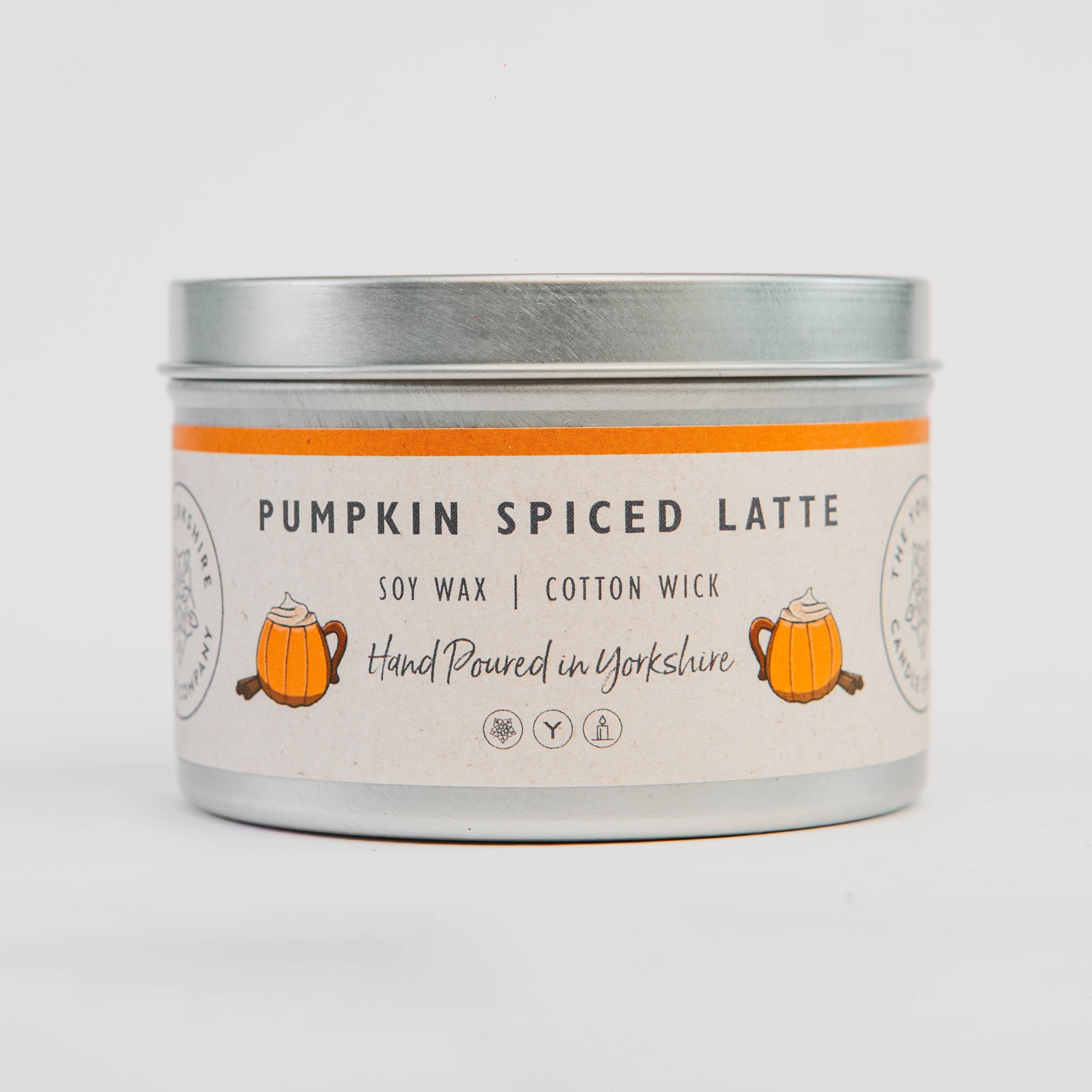 Candle tin labeled 'Pumpkin Spiced Latte' on a light gray background