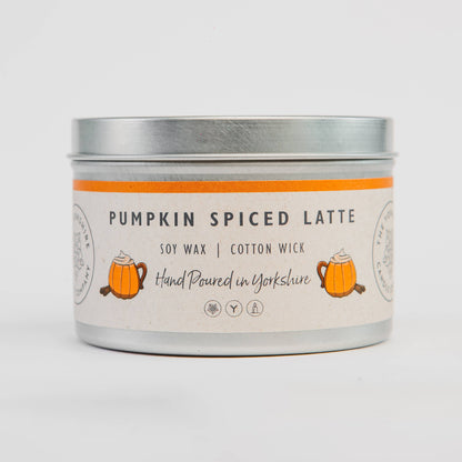 Candle tin labeled 'Pumpkin Spiced Latte' on a light gray background