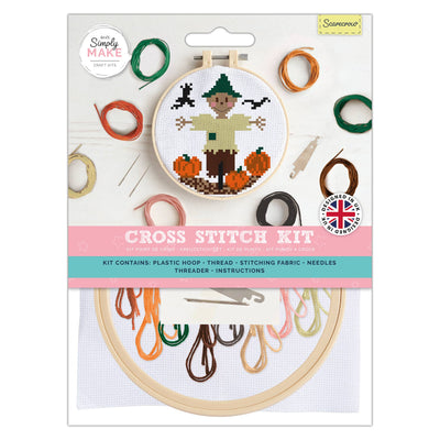 Cross stitch kit packaging with embroidery hoop and thread colors on a white background