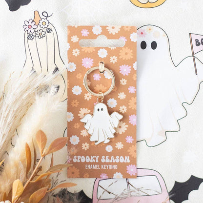 Spooky season enamel keyring on a floral patterned card with Halloween-themed decorations.