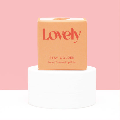 Lip balm packaging with 'Lovely' branding on a pink background
