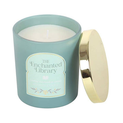 Candle in a light blue container with a gold lid labeled 'The Enchanted Library' on a white background.