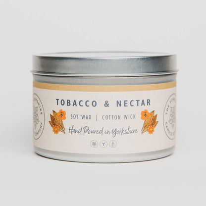 Candle tin labeled 'Tobacco & Nectar' on a light gray background