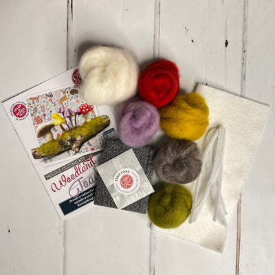 Colorful wool roving balls with a craft book on a wooden surface