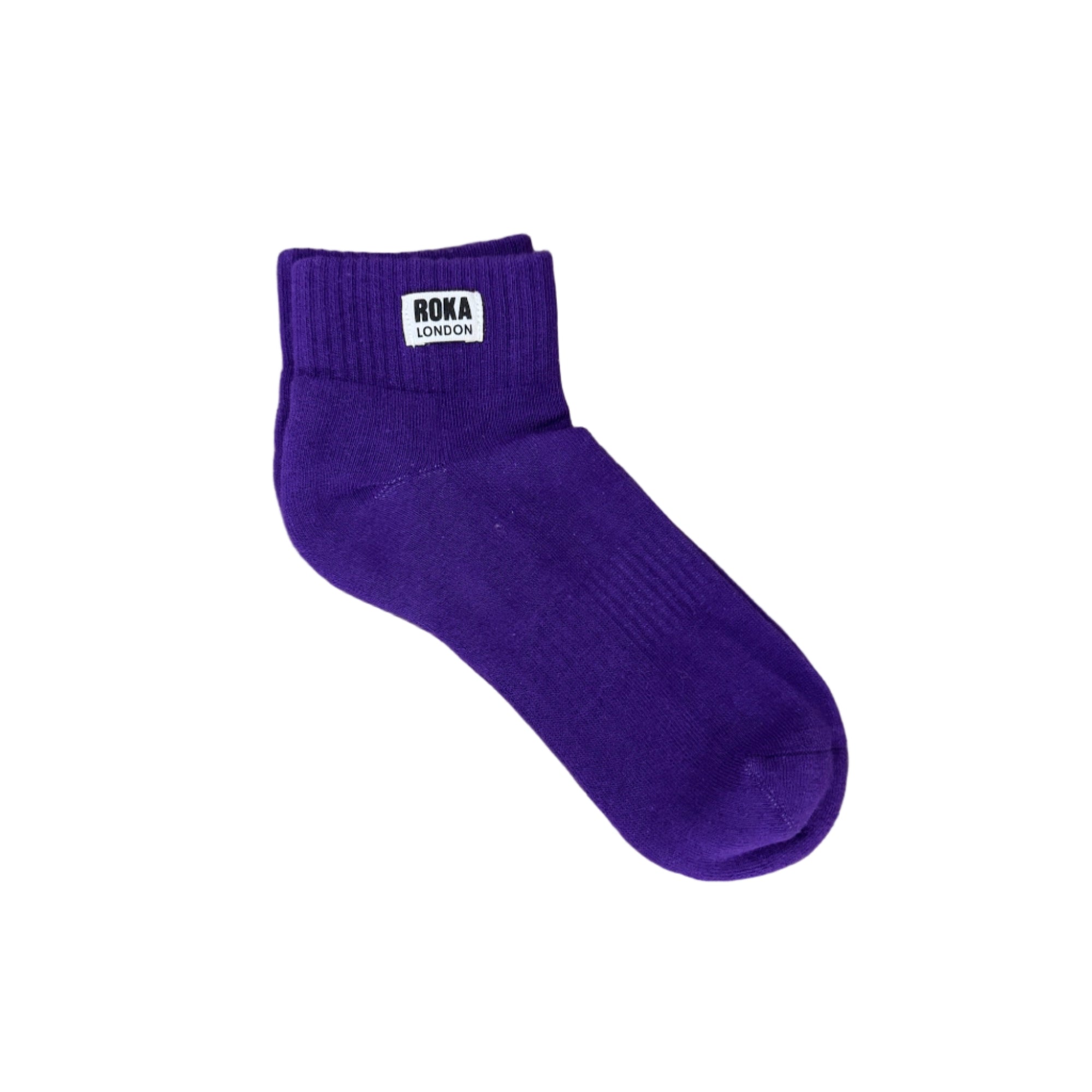 Purple sock with a brand label on a wooden surface